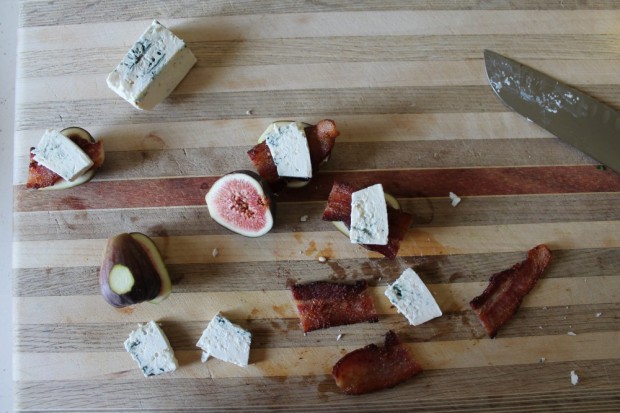 Slice figs in half, lengthwise. Trim stem off. Slice a small piece off of the opposite side so that the figs will sit level. Place a piece of slab bacon, already cooked about 90 % through on top of the fig half. Top bacon with a piece of blue cheese. Drizzle EVOO over cheese.