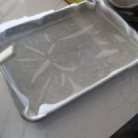 Spray pan with non-stick. It acts as "glue" for the parchment paper.